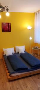 a large bed in a room with a yellow wall at Buda Super Panorama in Budapest