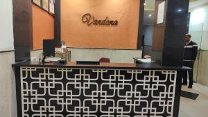 a man standing at a desk in a lobby at Hotel Vandana in Kota