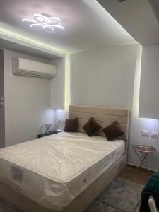 a bedroom with a large bed with a ceiling at Nice Studio on the Roof in Sheikh Zayed