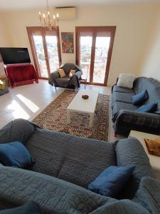 uma sala de estar com dois sofás e uma mesa em villa panorama seaview em Tessalônica