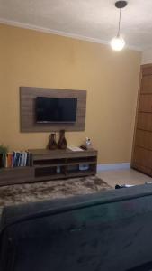 sala de estar con TV de pantalla plana en la pared en Apto mobiliado próximo hospital angelina caron. ( ver app Airbnb), en Campina Grande do Sul