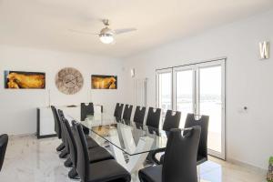 jadalnia ze szklanym stołem i krzesłami w obiekcie Villa Casa Colina - Algarve - 7 Bedrooms, Private location w mieście Estoi