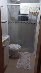 y baño con ducha, aseo y alfombra. en Apto mobiliado próximo hospital angelina caron. ( ver app Airbnb), en Campina Grande do Sul