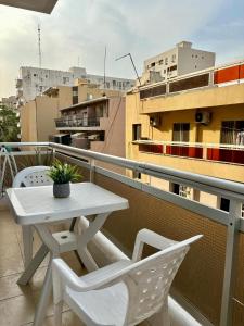 a white table and chairs on a balcony at Le Dakar Roi - Studio Centre Ville Très Bien Situé in Dakar