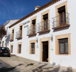 un edificio blanco con balcones en un lateral en Casa Rural Andalucia Mia, en Aracena