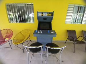 um quarto com uma consola de videojogos e cadeiras em Rancho Santana em Socorro