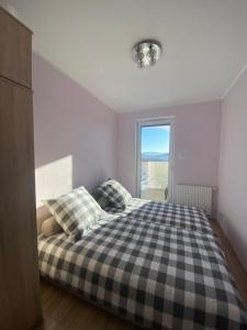 sypialnia z czarno-białym łóżkiem szachowym w obiekcie Apartament Rakownica w Jeleniej Górze
