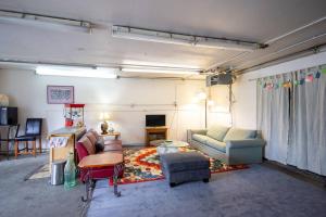- un salon avec un canapé et une télévision dans l'établissement Spenard Guest House - The Lotus Room, à Anchorage