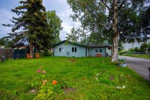un patio con una casa azul y un árbol en Spenard Guest House - The Lotus Room, en Anchorage