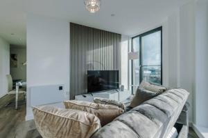 a living room with a couch and a tv at Stunning 2-Bed Premium Apartment - Free WI-FI in Preston