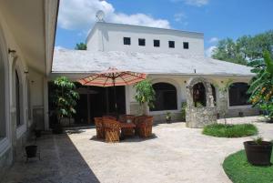 een patio met een tafel en stoelen en een parasol bij Casa Cyca, casa de campo, hasta 50 en cama c/clima 