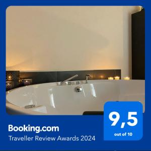 a white tub in a bathroom with a sign that reads travel review awards at Le Colonne B&b in Ercolano