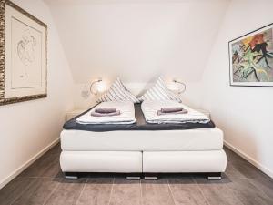 a bedroom with a white bed with two pillows at Ferienhaus am Yachthafen in Peenemünde in Peenemünde