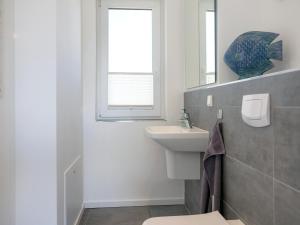 a bathroom with a sink and a toilet and a window at Ferienhaus am Yachthafen in Peenemünde in Peenemünde +32 photos