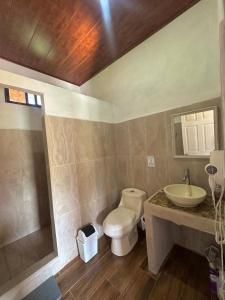 a bathroom with a toilet and a sink at Villa Marina, Nosara in Río Seco
