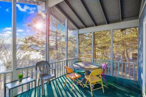 a screened in porch with a table and chairs at Ship Dock Lane A in Osage Beach