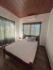 een slaapkamer met een groot bed en een houten plafond bij Villa Marina, Nosara in Río Seco