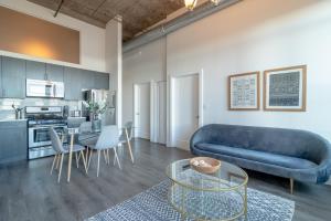 シカゴにあるMcCormick Place modern 2br-2ba Loft with optional parking for 6 guestsのリビングルーム(青いソファ、テーブル付)