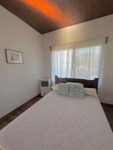 a bedroom with a large white bed and a window at Villa Marina, Nosara in Río Seco
