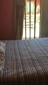 a bedroom with a bed with a striped bedspread and a window at Habitación en Casa Familiar 