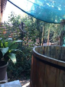 a wooden tub in a garden with a fence at Habitación en Casa Familiar 