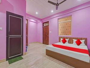 a bedroom with pink walls and a bed with a door at Srv Inn in Nilmatha