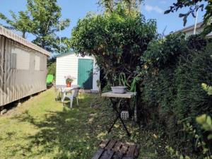 a small garden with a table and a fence at Mobil home avec terrasse 4 personnes in Ambon