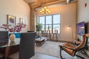 a living room with a table and chairs and a large window at McCormick Place modern loft with an amazing city skyline view and optional parking for 6 guests in Chicago
