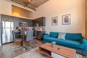 a living room with a blue couch and a kitchen at McCormick Place modern loft with an amazing city skyline view and optional parking for 6 guests in Chicago