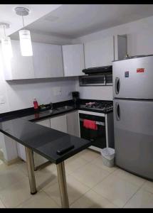 Il comprend une cuisine équipée d'un réfrigérateur et d'une table. dans l'établissement Apto en Milan. Zona rosa, à Manizales