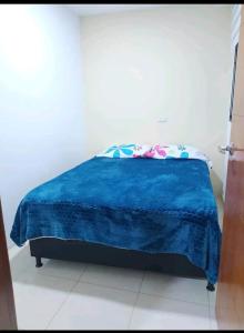 - une chambre avec une couverture bleue sur un lit dans l'établissement Apto en Milan. Zona rosa, à Manizales