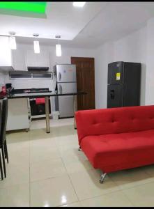 - un salon avec un canapé rouge et un réfrigérateur dans l'établissement Apto en Milan. Zona rosa, à Manizales
