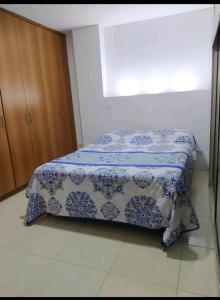 - une chambre dotée d'un lit avec une couverture bleue et blanche dans l'établissement Apto en Milan. Zona rosa, à Manizales