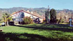una casa con un patio de hierba delante de ella en CASA IRIANA - Chimenea I Jardín I Barbacoa, en Ourense