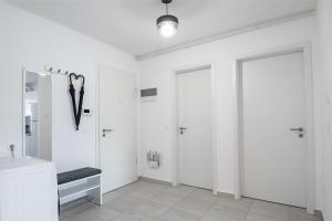 un bagno bianco con due docce e un lavandino di Apartment with free parking near Coresi Mall by MM Apartments a Braşov