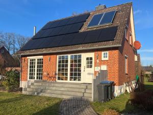 una casa con paneles solares en el techo en Zimmer m. Doppelbett, Zustellbett f. 3. Pers. mgl. en Reppenstedt