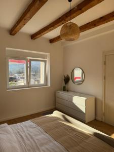a bedroom with a bed and a dresser and a mirror at Apartment 107 in Cetinje