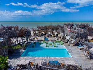 a swimming pool with chairs and the ocean in the background at Bethel Playa Mayapo in Mayapo