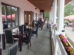 a restaurant with tables and chairs and people on a patio at Tee Motell in Viitna