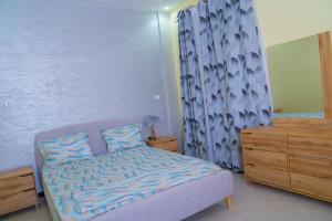 Dormitorio pequeño con cama y vestidor en Immeuble INNA en Ziguinchor