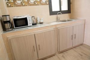 - un comptoir de cuisine avec un four micro-ondes et un évier dans l'établissement Immeuble INNA, à Ziguinchor