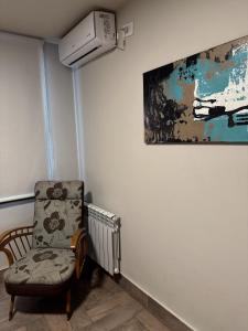 um quarto com uma cadeira e um quadro na parede em Departamento confortable em Mendoza