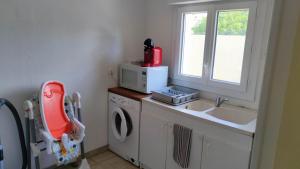 een keuken met een wastafel en een wasmachine bij Dépendance 4 personnes in Saint-Loubès