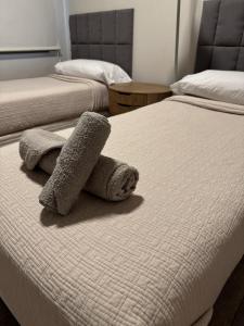 2 camas en un dormitorio con toallas en la cama en Departamento confortable en Mendoza
