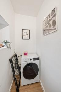 una lavadora blanca en una esquina de una habitación en Sali Homes - Neuenstadt am Kocher, en Neuenstadt am Kocher