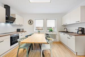 a kitchen with a wooden table and chairs at Sali Homes - Neuenstadt am Kocher in Neuenstadt am Kocher