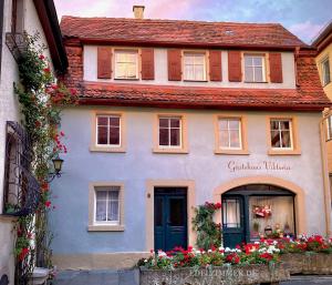 una casa blanca con flores delante en Gästehaus Edelzimmer en Rothenburg ob der Tauber