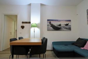 sala de estar con mesa y sofá azul en Il Giardino di Limoni, en Marino
