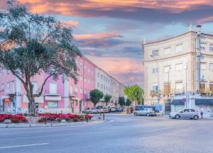 una calle de la ciudad con coches aparcados en la calle en April Square by Lisbon with Sintra en Amadora