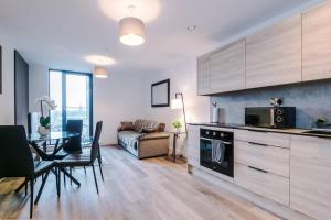 een keuken en een woonkamer met een bank en een tafel bij Luxury King Size 1-Bed City Apartment - Free WI-FI in Preston